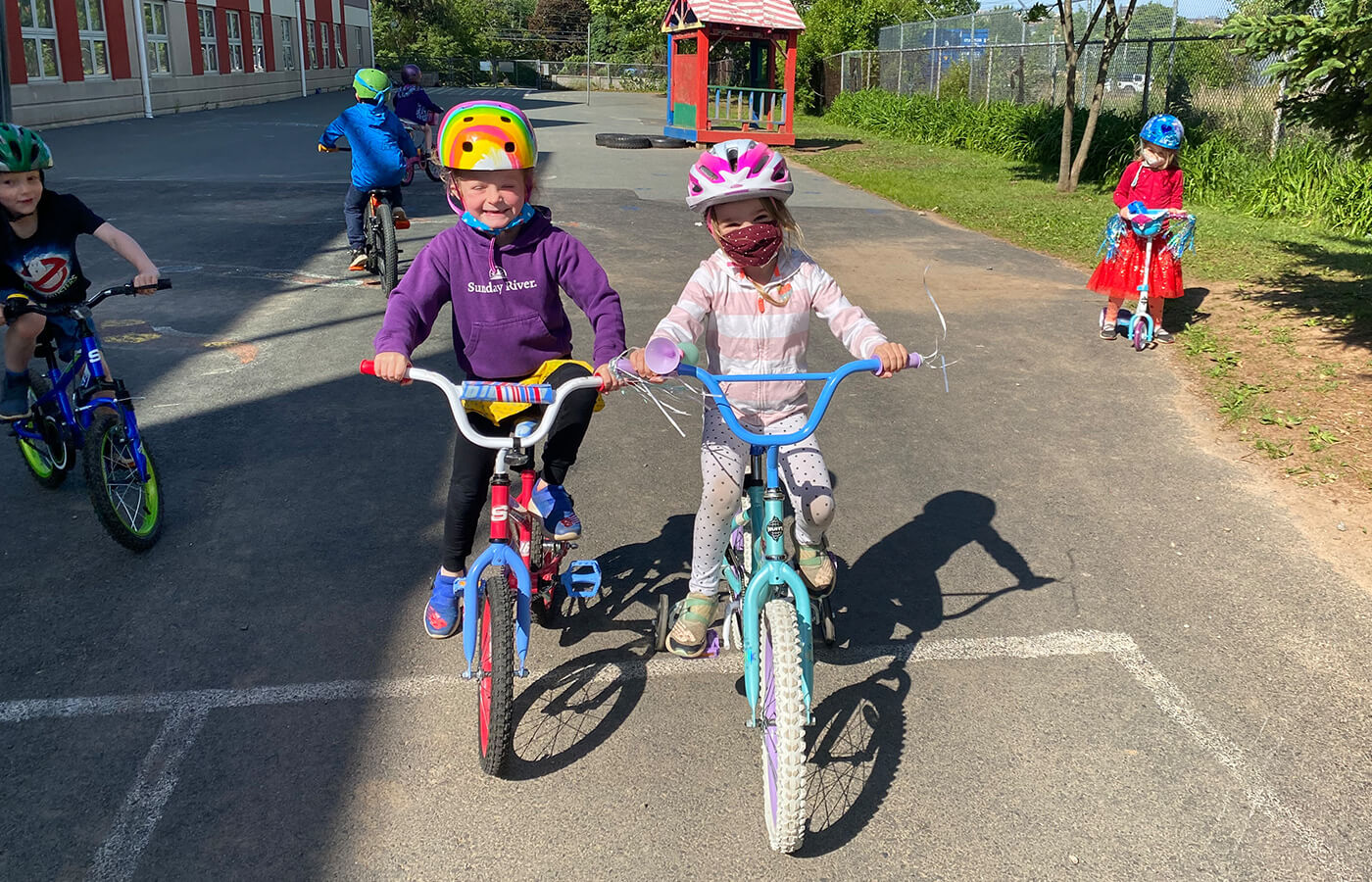 Kids on bicycles and scooters outdoors