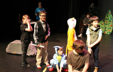 Students in costume rehearsing a play