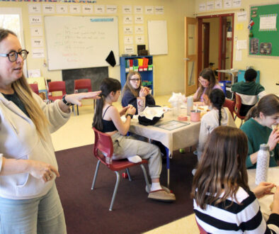 The French Language Club host introduces the featured treat to students.