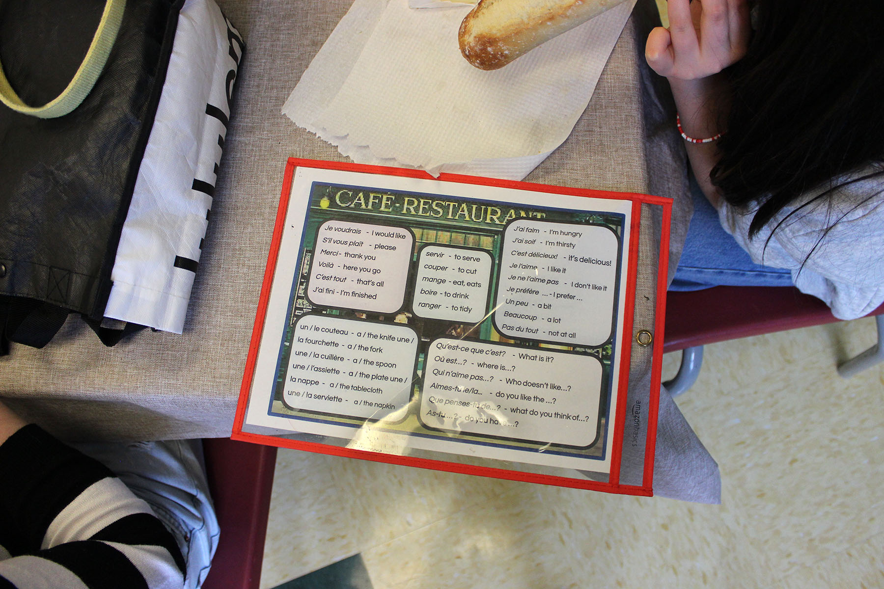 French Language Club vocabulary prompts are on a café table.