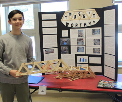 In preparation for the Halifax Sci-Tech Expo, a Jr High student presents his science fair research using a model and a tri-fold display.